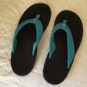 Olukai Ohana Turquoise and black flip flop.